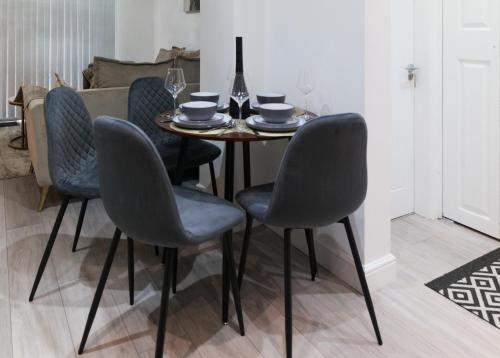 tavolo da pranzo con 4 sedie e bicchiere di vino di Downtown Cozy House in Manchester a Manchester