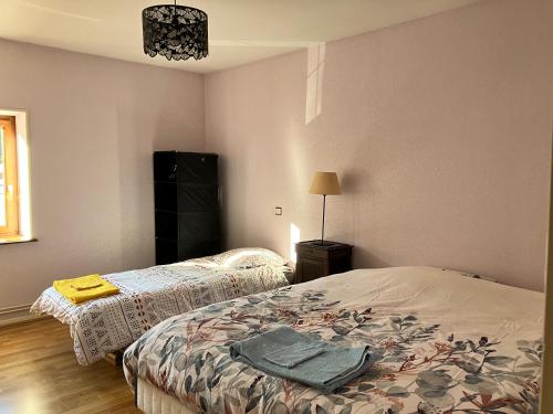 - une chambre avec 2 lits et une lampe dans l'établissement Appartement indépendant dans jolie ferme vosgienne 1814 rénovée, à Remiremont