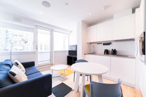 a living room with a couch and a table at Stylish Retreats on Olympic Way in London