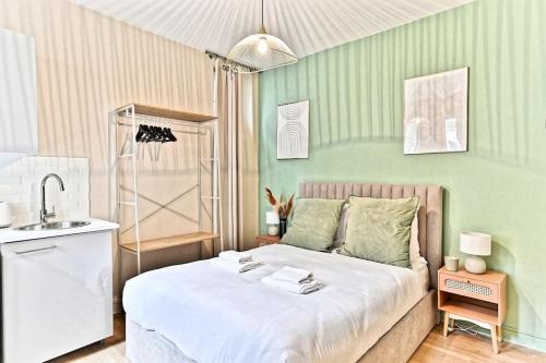 une petite chambre avec un lit et un lavabo dans l'établissement Studio au centre de Paris 14ème - II, à Paris