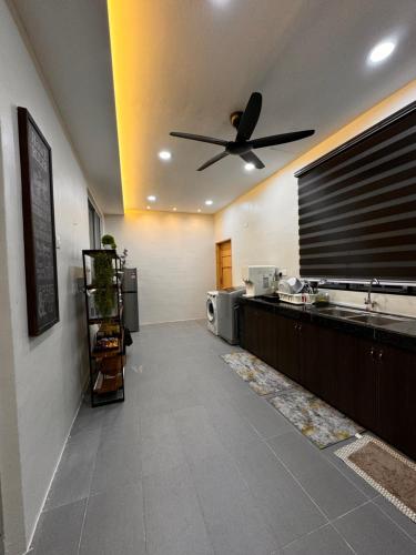 a kitchen with a ceiling fan and a counter at Mia homestay in Teluk Intan