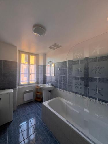 une salle de bain avec une baignoire et un lavabo dans l'établissement 3 pièces, tout à pied et tout équipé, avec balcon et machines à laver, Parking offert et bus direct aéroport de Nice, à Grasse
