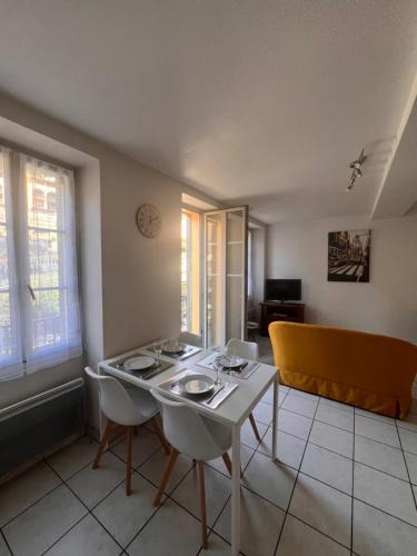 un salon avec une table et des chaises blanches dans l'établissement 3 pièces, tout à pied et tout équipé, avec balcon et machines à laver, Parking offert et bus direct aéroport de Nice, à Grasse