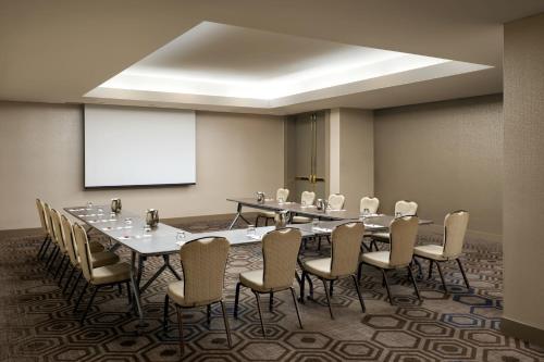 a conference room with tables and chairs and a projection screen at Toronto Marriott City Centre Hotel in Toronto
