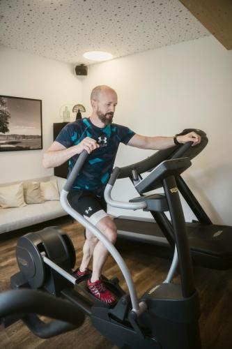 a man sitting on a treadmill in a gym at Ölerhof in Haag am Hausruck