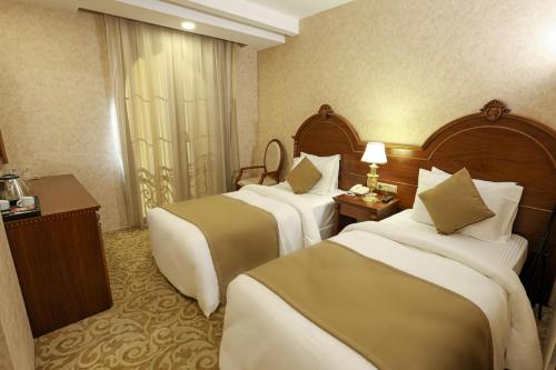 a hotel room with two beds and a window at PRiNCESS MAYA HOTEL in Seyhan