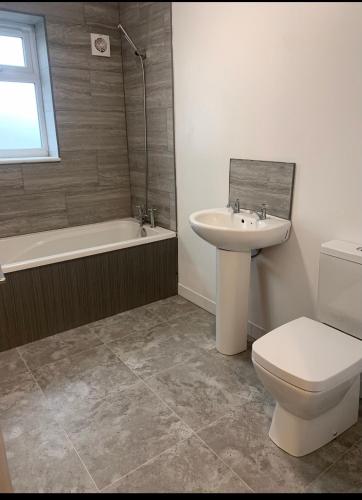 a bathroom with a sink and a toilet and a bath tub at 4 Bedroom Contractors House in Sheffield