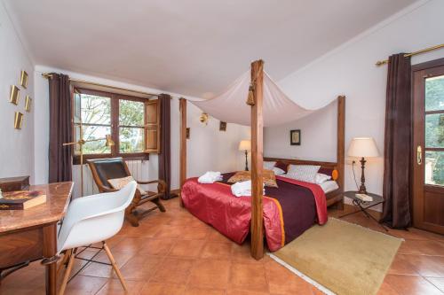 une chambre avec un lit à baldaquin et un bureau dans l'établissement Suite Mestral im Es Llobets, à Llucmajor