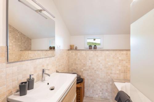a bathroom with a sink and a tub at La Tour du Blé - gîtes et chambres d'hôtes in Salornay-sur-Guye