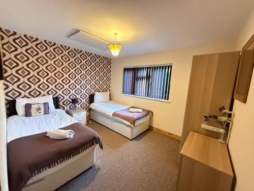 a hotel room with two beds and a window at Appleton Apartments in Newark upon Trent