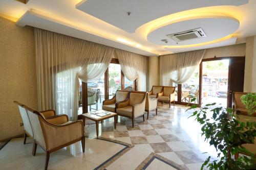 a waiting room with chairs and tables and windows at PRiNCESS MAYA HOTEL in Seyhan