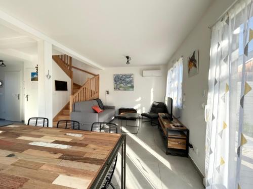 a living room with a table and a couch at Gîte du Moulin- Clim Parking Vélo Tourisme - CLG Savoie in Villard-dʼHéry