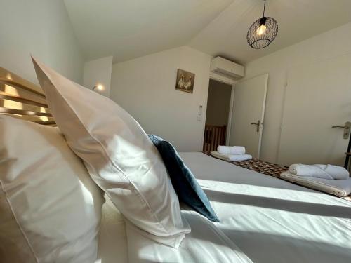 a bedroom with a bed with white sheets and pillows at Gîte du Moulin- Clim Parking Vélo Tourisme - CLG Savoie in Villard-dʼHéry