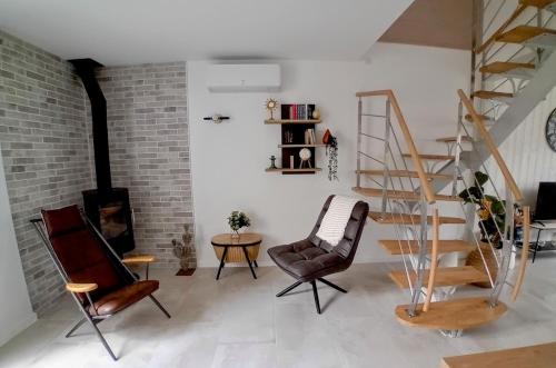 - un salon avec un escalier, des chaises et une table dans l'établissement Thoiras La Belle de Saint-Martin, à Saint-Martin-de-Ré