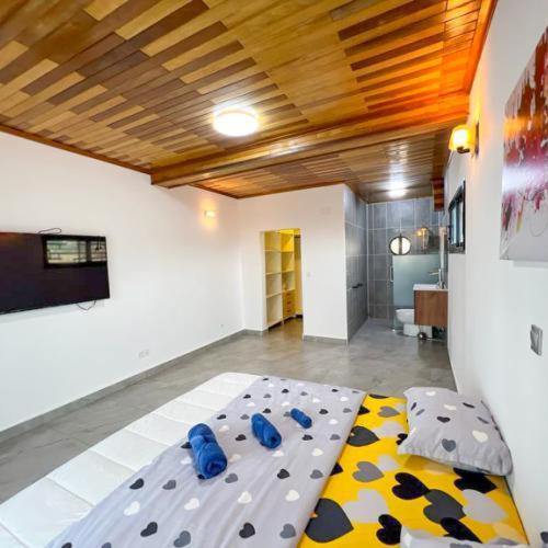 a bedroom with a bed with a polka dot blanket at Résidences LELYSSE in Méyo