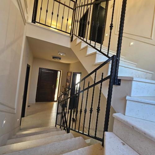 a staircase in a home with a wrought iron railing at Plitvice Falls Cottage in Plitvica selo