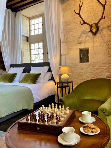 a bedroom with a bed and a chess board on a table at Gîte d'exception - Manoir de Sacquenay in Sacquenay