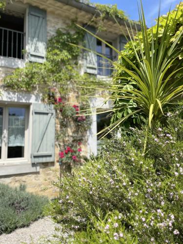 une maison avec des fleurs et des plantes devant dans l'établissement Le Domaine de La Tuilerie - Gite de charme en bord de riviere avec piscine, à Serviès-en-Val