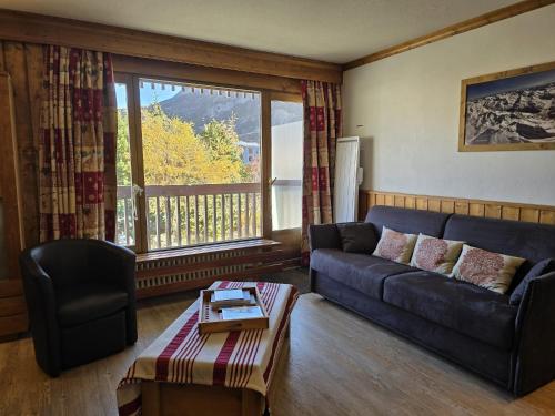 a living room with a couch and a large window at Bel appartement 4 pers, Tignes Le Lac in Tignes