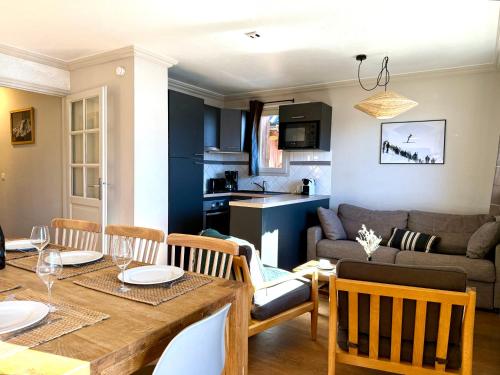 a dining room and living room with a table and chairs at Appartement 6 8 personnes, balcon vue montagne, ski aux pieds in Val Thorens