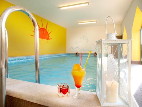 ein Bad mit einem Pool und einem Getränk in der Unterkunft Hotel Merano in Brenzone sul Garda