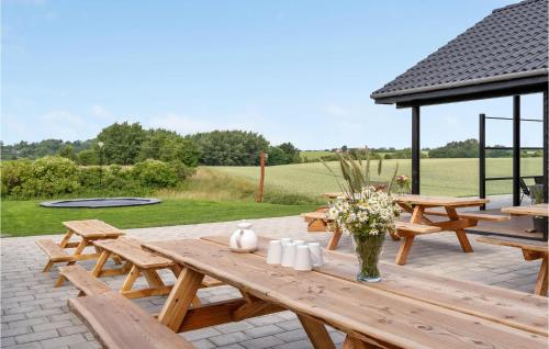 a wooden picnic table with flowers on a patio at Cozy Home In Spøttrup With Wifi in Spottrup
