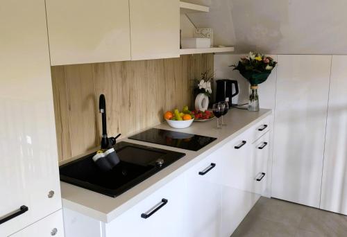 a kitchen with a sink and a bowl of fruit at Restauracja Dajana in Bełchatów