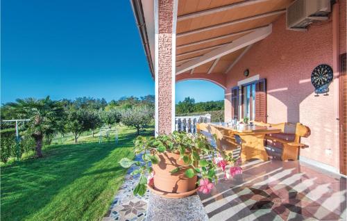 a porch with a wooden table and a potted plant at Holiday Home Livaki Iv in Muntrilj