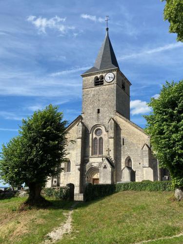 an old church with a clock tower on a hill at Gîte d'exception - Manoir de Sacquenay in Sacquenay