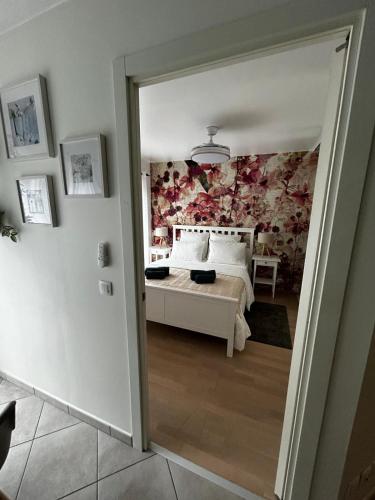 - une chambre avec un lit orné d'un mur fleuri dans l'établissement La Orquidea - sleeps 2 to 4 - 3, à Aix-les-Bains