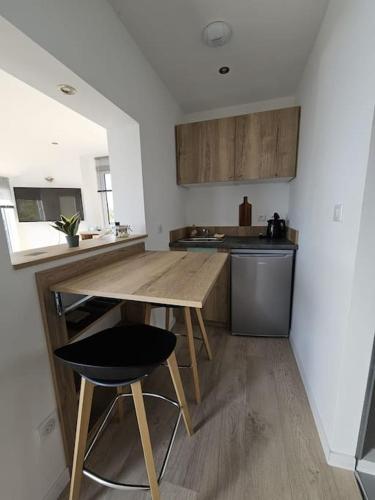 une cuisine avec une table en bois et une chaise noire dans l'établissement Gîte La Capitainerie, à Offendorf