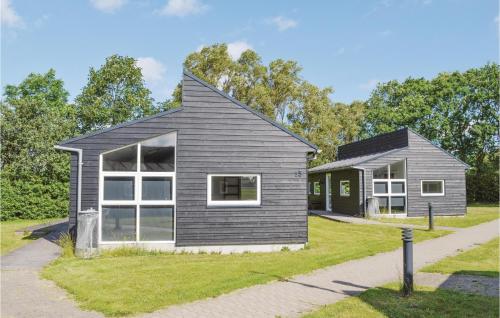 a gray house with white windows and a driveway at Holiday Home Halvejen Hytte Spjald I in Spjald