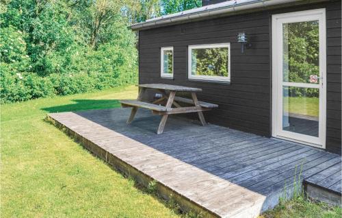 a picnic table on a deck next to a house at Holiday Home Halvejen Hytte Spjald I in Spjald