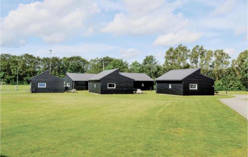 a group of black cabins on a grass field at Holiday Home Halvejen Hytte Spjald I in Spjald