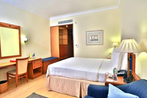 a hotel room with a bed and a desk at The Fern-An Ecotel Hotel, Kochi in Cochin