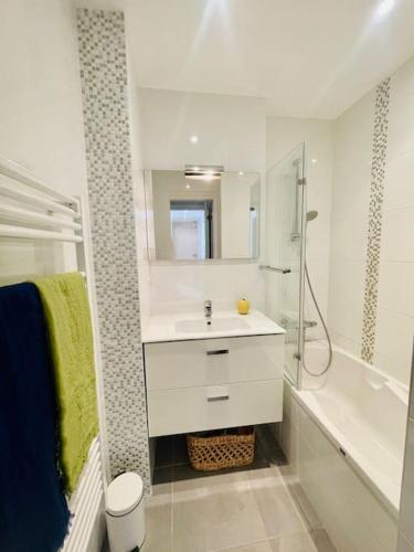 une salle de bain blanche avec un lavabo et une douche dans l'établissement Les Mouettes Face Mer La baule, à La Baule