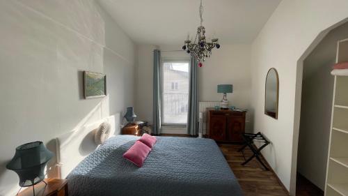 a bedroom with a blue bed with pink pillows at Feine 2-Zimmer Dachgeschoßwohnung in Klagenfurt