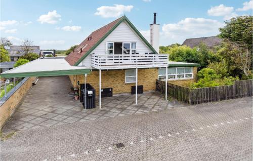 a house with a balcony on a brick driveway at Holiday Apartment Skagen 01 in Skagen
