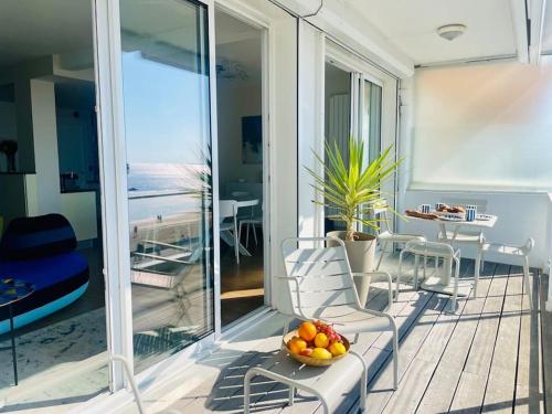 - un balcon avec un bol de fruits sur une table dans l'établissement Les Mouettes Face Mer La baule, à La Baule