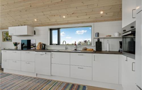 a kitchen with white cabinets and a large window at 3 Bedroom Lovely Home In Hjørring in Hjørring