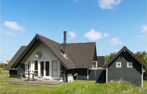 a black house with a table in front of it at Holiday Home Slettevej Ii in Skagen