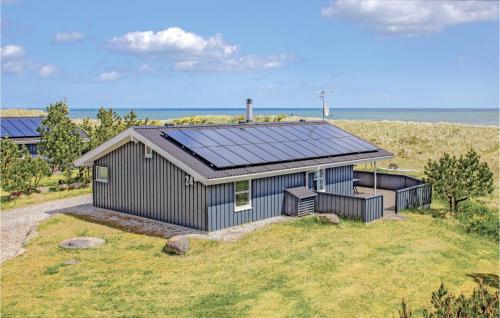 a house with a solar roof on top of a field at Holiday Home Sæby With Fireplace 01 in Sæby