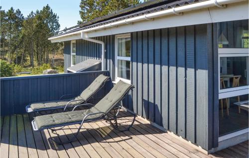 a chair sitting on a deck next to a house at Holiday Home Sæby With Fireplace 01 in Sæby