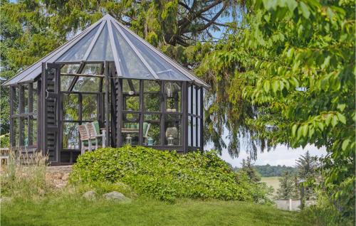 a gazebo with a chair in a garden at Gorgeous Home In Tårs in Tårs