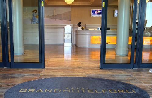 a lobby with a grandidoria sign on the door of a building at Grand Hotel Forlì in Forlì