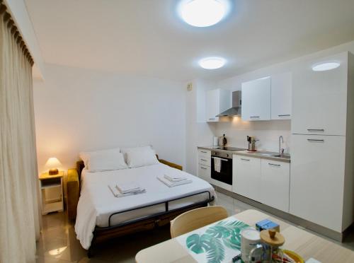 une petite chambre avec un lit et une cuisine dans l'établissement Monte Carlo Terrace Monaco, à Beausoleil