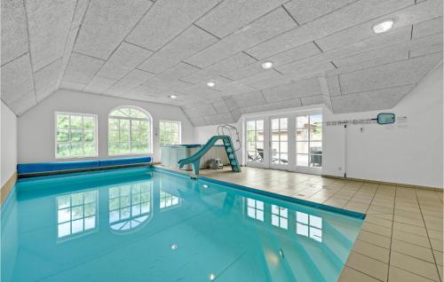 an indoor swimming pool with blue water in a room at Awesome Home In Ulfborg With Kitchen in Ulfborg