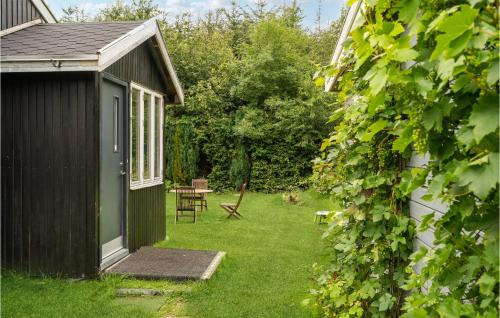 a garden with a table and chairs and a building at 2 Bedroom Lovely Home In Spøttrup in Spottrup