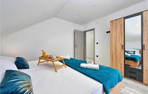 a bedroom with a large bed and a table at Lovely Home In Vinogradi Ludbreski in Ludbreg