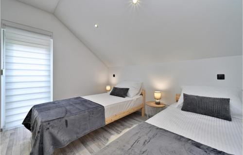 two beds in a bedroom with white walls at Lovely Home In Vinogradi Ludbreski in Ludbreg